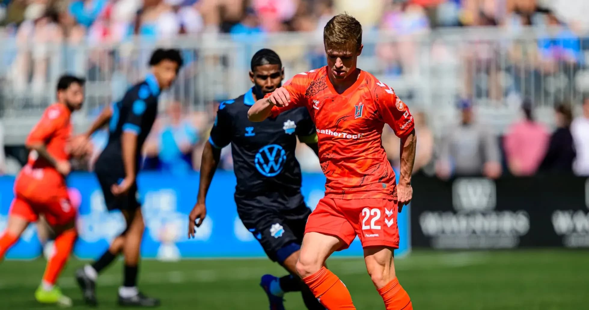 Player in orange jersey dribbling the ball Player in orange jersey dribbling the ball