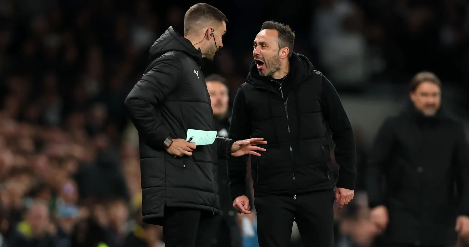 Two coaches discussing during a football match Two coaches discussing during a football match