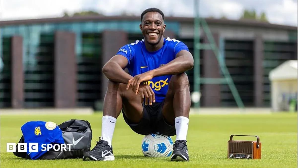 Player sitting on field with soccer ball and gear Player sitting on field with soccer ball and gear