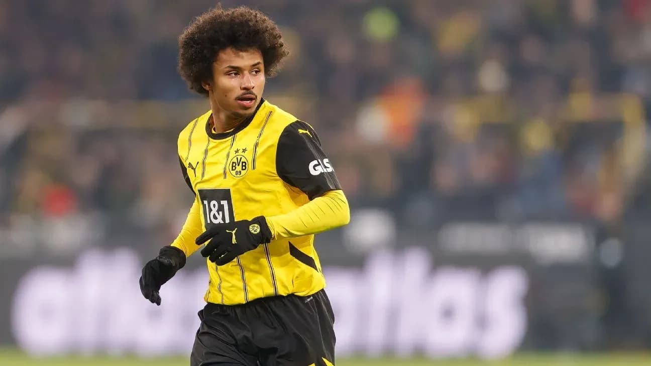 Player in Borussia Dortmund jersey on the field Player in Borussia Dortmund jersey on the field
